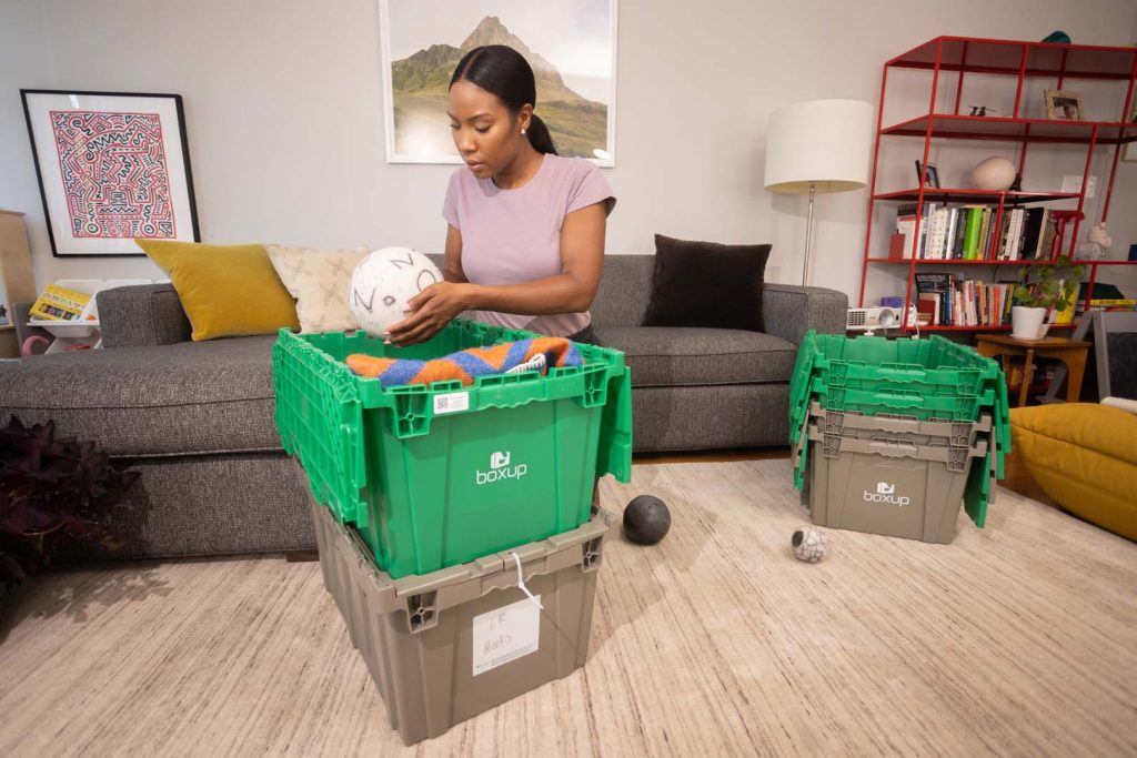 A Woman Unpacking Plastic Moving Bins